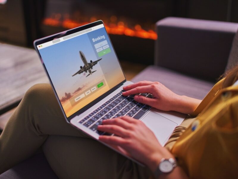 A woman looks at a flight comparison website on her laptop