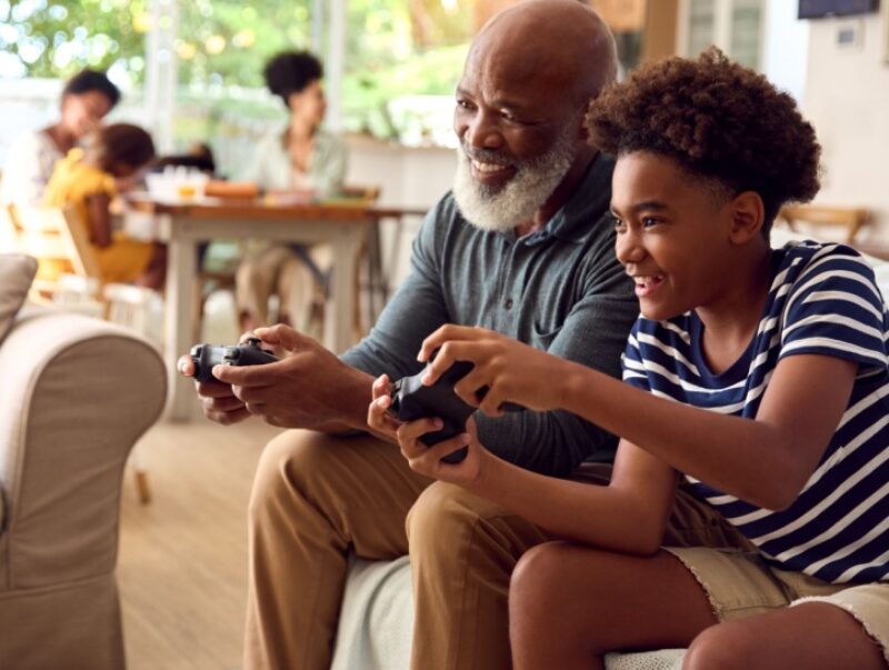 A man plays video games with his grandson