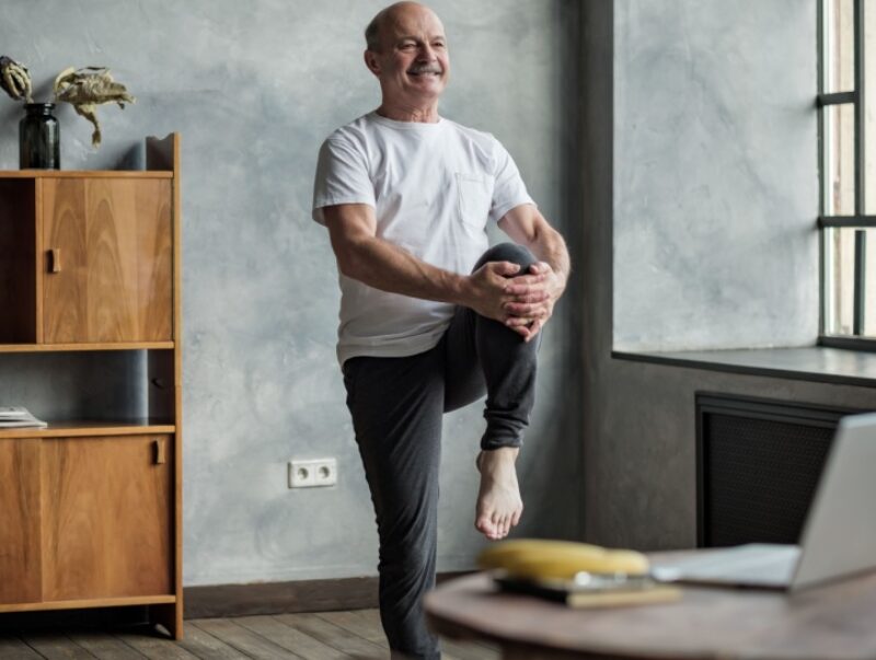 An older man balancing on one leg