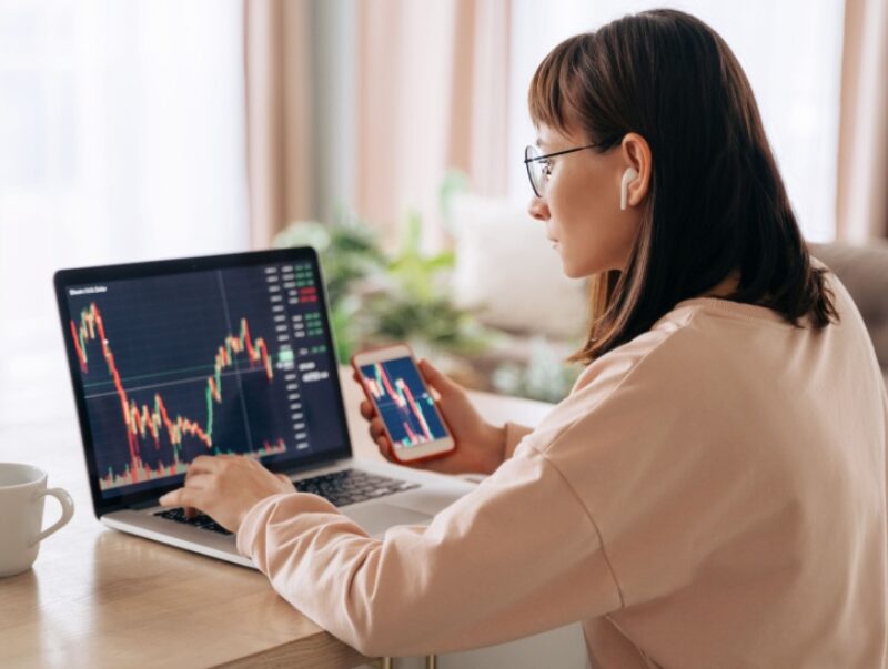 A woman checking investment graphs on a computer