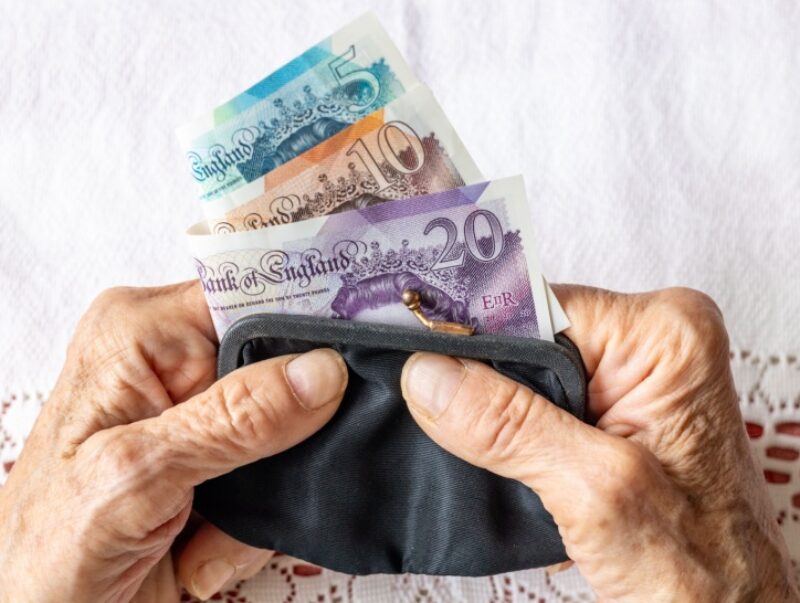 A person holding a purse with cash inside