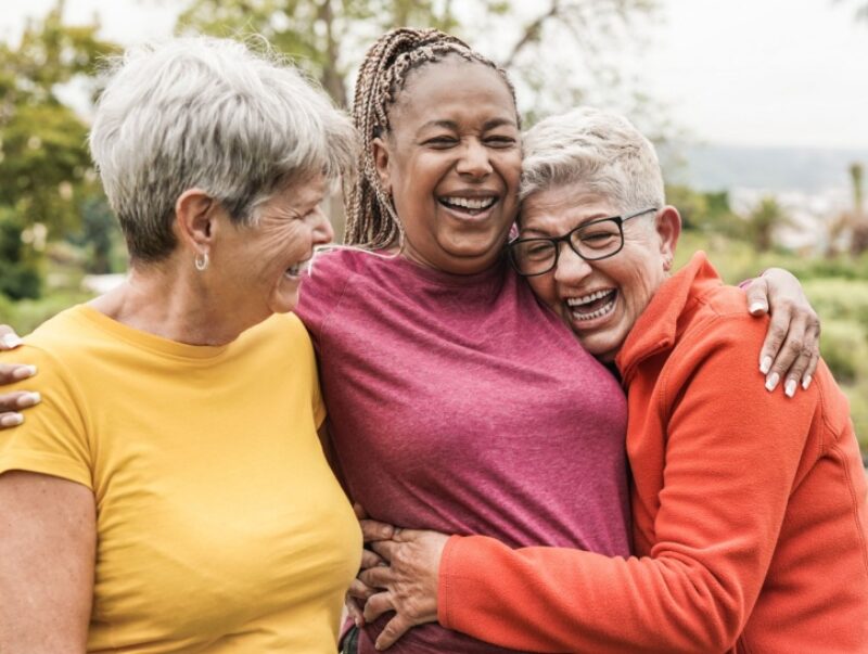 Three women laugh together