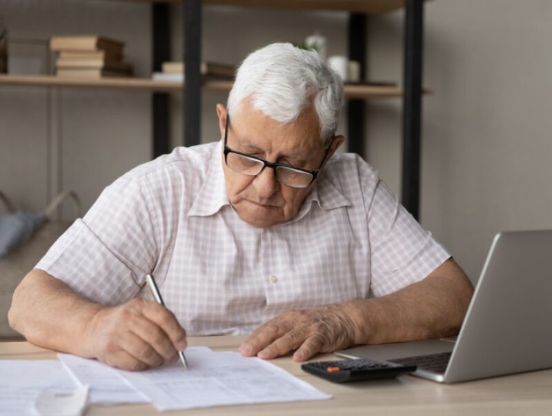 An older man signing some paperwork