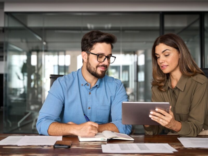A woman showing a man something on a tablet
