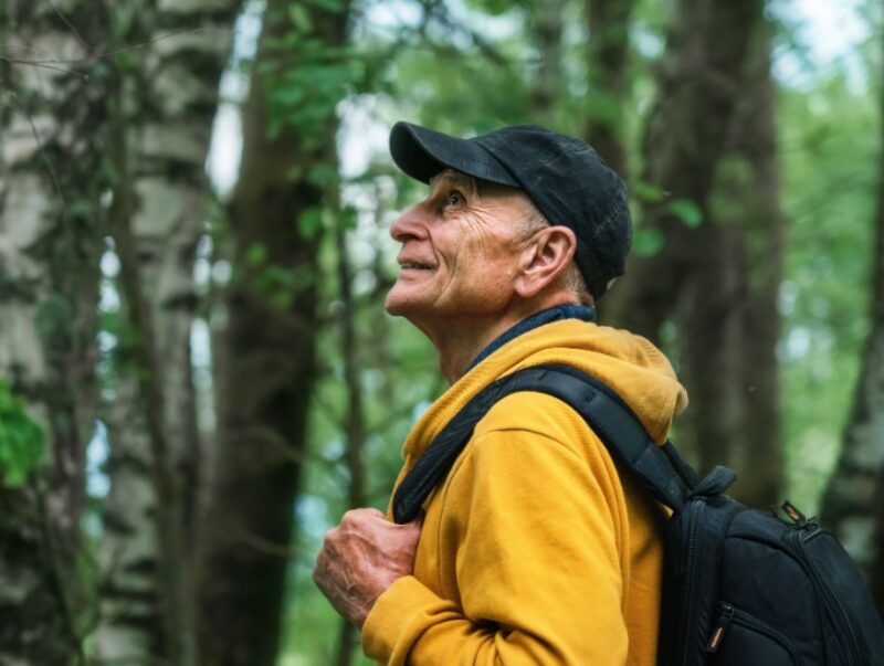 A happy older man hiking in the forest