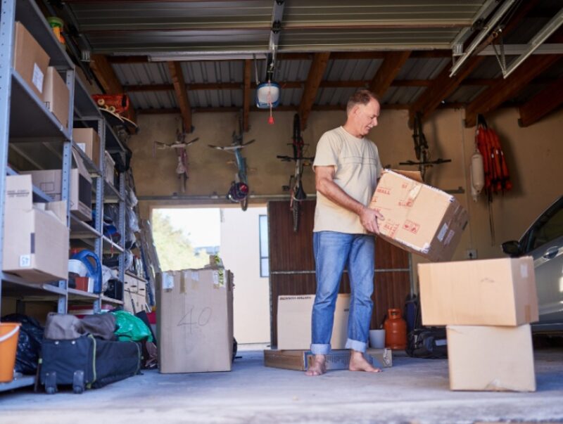 A man clearing boxes out of a garage