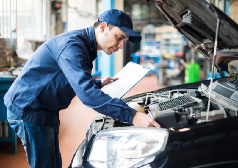 A mechanic checking the engine of a car