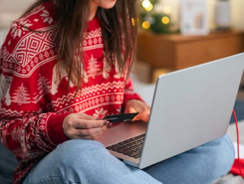 A woman in a Christmas jumper shopping online