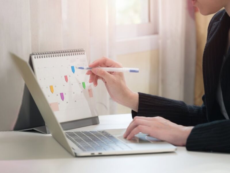 Person filling out events on a calendar