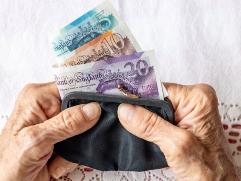 A person holding a purse full of cash