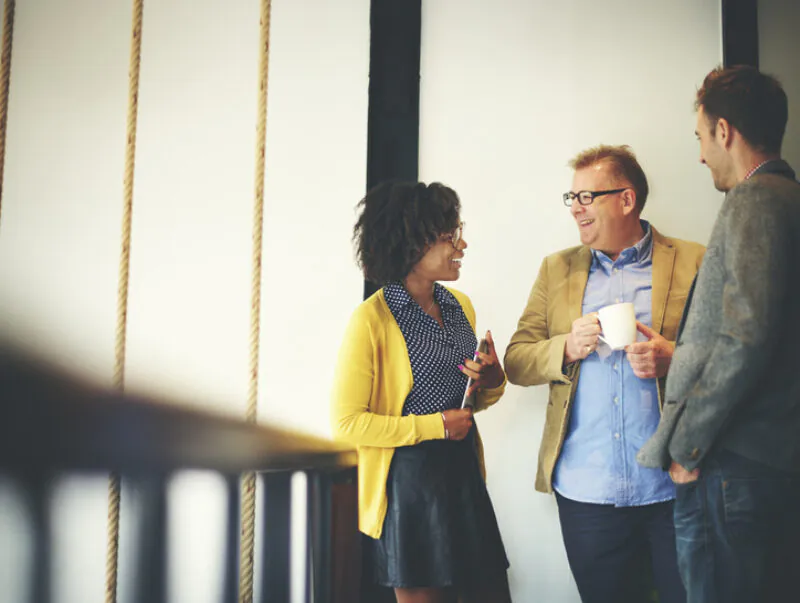 Three colleagues chatting during a coffee break