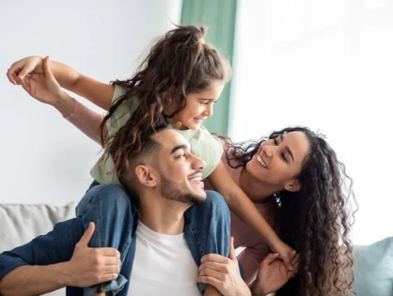 Two parents play with their child