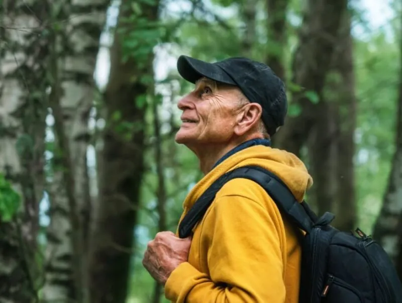 A happy older man hiking in the forest